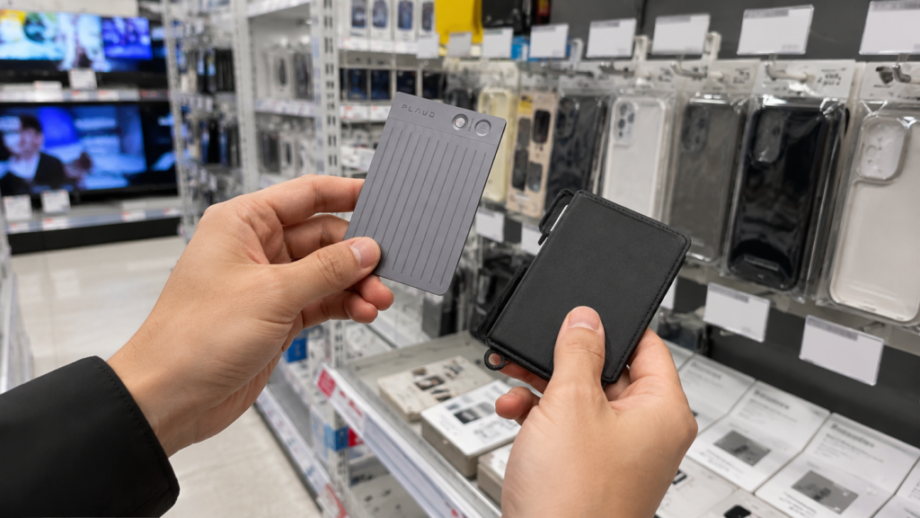Customer holding and comparing a PLAUD AI voice recorder with its case inside an electronics retail store